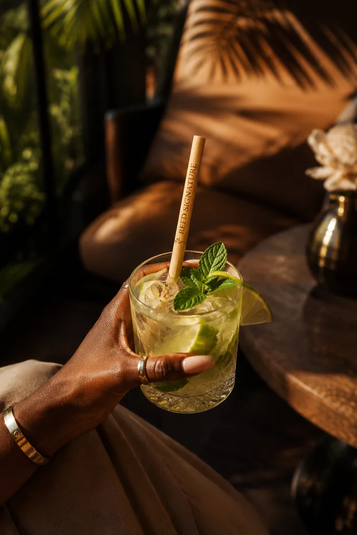Cocktail servi avec une paille gravée REED SIGNATURE dans un lounge